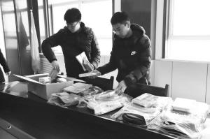 田洋(右)和学校工作人员整理捐给孩子的学习用品.jpg