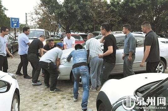 十多名好心人一起抬车，帮陈小姐解围。.jpg