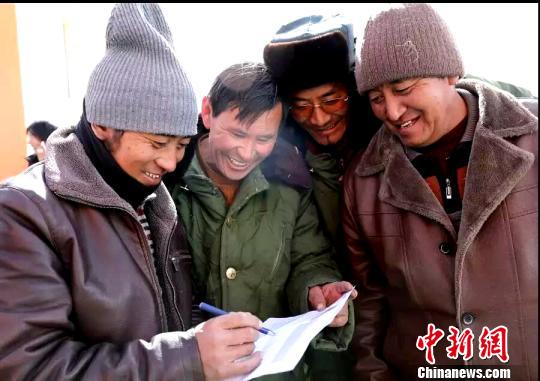 图为捐赠方与牧民签收物资。　李玉峰 摄