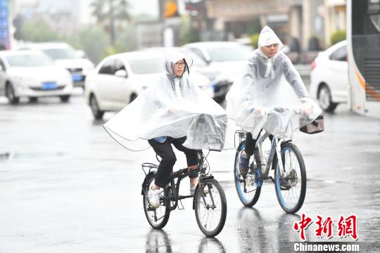 市民在雨中出行。　张浪 摄