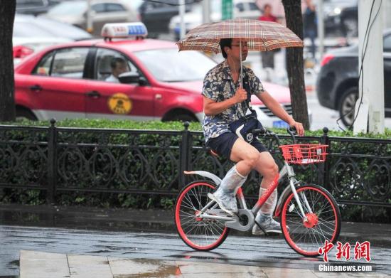 8月17日，辽宁沈阳的天气为小到中雨转雷阵雨，市民全副武装在雨中出行。当日，辽宁省气象灾害监测预警中心12时59分发布暴雨橙色预警信号。沈阳天气为小到中雨转雷阵雨。<a target='_blank' href='http://www.chinanews.com/'>中新社</a>记者 于海洋 摄